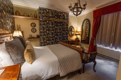 a bedroom with a bed and a table and a mirror at The Plough Inn in York