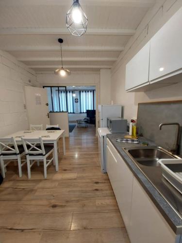 une cuisine avec un évier et une table avec des chaises dans l'établissement Welcome Calais Centre St Pierre Fontinettes, à Calais