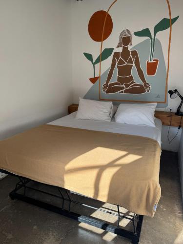 a bed with a picture of a woman sitting in meditation at ESO Santa Teresa in Santa Teresa Beach