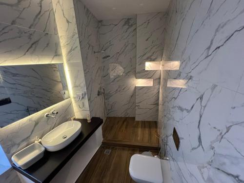 a bathroom with a white sink and a toilet at Katharsis Palace 15th Century Art Hotel at Naxos Old Town II in Naxos Chora