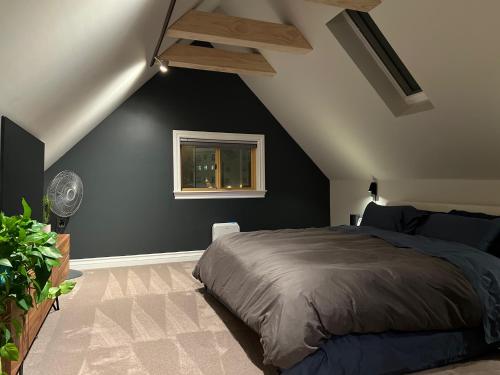 a bedroom with a bed and a black wall at Awesome Remodeled House in Denver