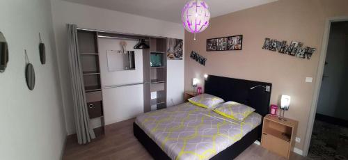 a bedroom with a bed and a pink lamp at Grand Appartement Luxe avec SAUNA et BAIN LED 50m de l océan avec belle terrasse pour manger CHIEN ADMIS 2 chambres pour 4 pers avec GRANDE BAIGNOIRE BALNEO SPA in Biscarrosse