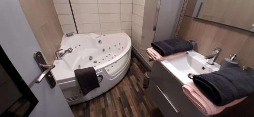 a bathroom with a tub and a sink at Grand Appartement Luxe avec SAUNA et BAIN LED 50m de l océan avec belle terrasse pour manger CHIEN ADMIS 2 chambres pour 4 pers avec GRANDE BAIGNOIRE BALNEO SPA in Biscarrosse