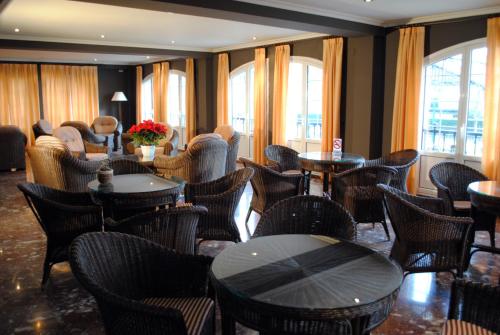 ein Restaurant mit Tischen, Stühlen und Fenstern in der Unterkunft Hotel Gernika - Adults Only in Gernika