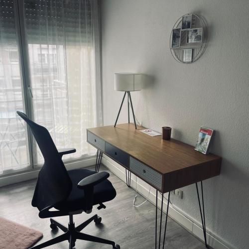 Cette chambre comprend un bureau avec une chaise et une lampe. dans l'établissement Studio proche Strasbourg, à Schiltigheim