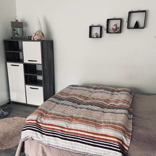 - une chambre avec un lit et trois photos sur le mur dans l'établissement Studio proche Strasbourg, à Schiltigheim