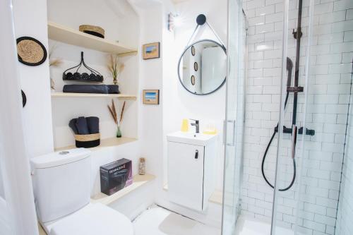une salle de bain blanche avec douche et toilettes dans l'établissement La Villa Au petit bonheur, à Honfleur