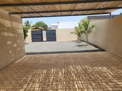 a brick courtyard with a palm tree in a building at Villa luxueuse à ngaparou saly center in Ngaparou