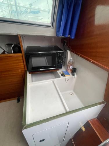 une cuisine vide avec un four micro-ondes dans une pièce dans l'établissement Voile d'Écume - Douce Nuit sur l'Eau, à Gruissan