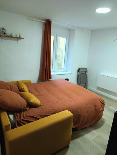 - une chambre avec un grand lit et une chaise jaune dans l'établissement Appartement calme hypercentre, à Clermont-Ferrand