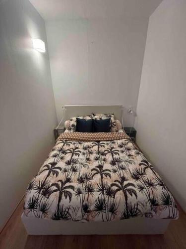 - une chambre avec un lit et une couverture plantée de palmiers dans l'établissement Appartement cosy, 10 min Château Versailles et 5 min Gare, à Versailles