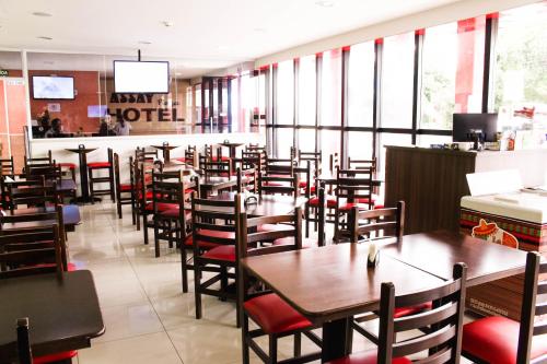 a restaurant with tables and chairs and a bar at Assay Plaza Hotel in Hortolândia
