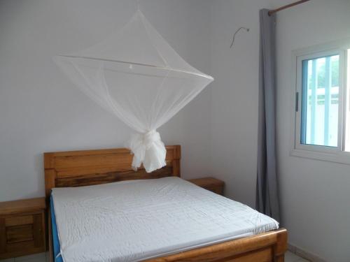 a bedroom with a bed with a net on it at Lagune Teranga in Somone