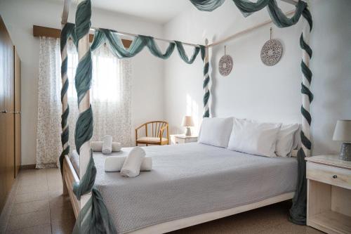 a bedroom with a canopy bed with white pillows at Nikolas Apartment in Pefki Rhodes