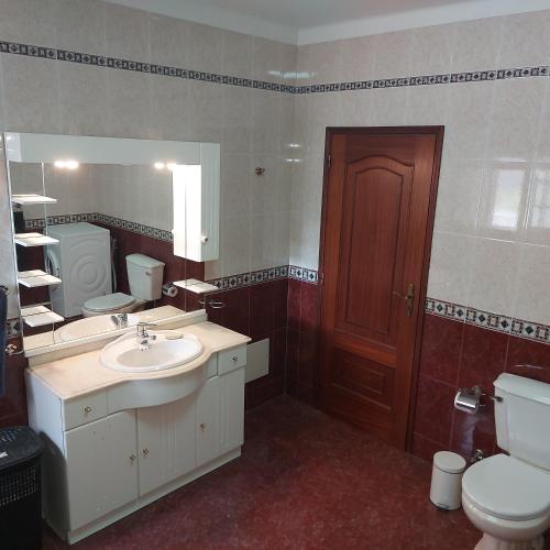 a bathroom with a sink and a toilet and a mirror at Apartment Casa Abundancia Grande in Vila Nova de Poiares