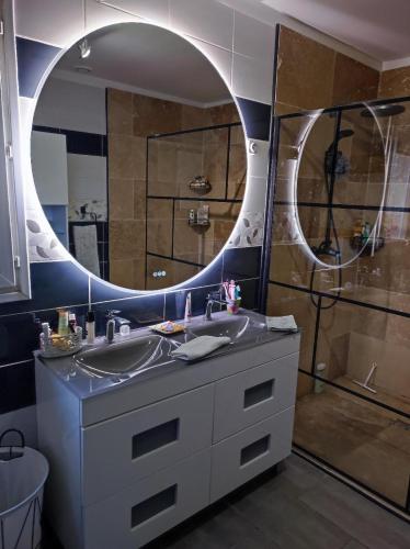 une salle de bain avec un lavabo et un miroir dans l'établissement Le Pavillon, à La Celle-sous-Gouzon