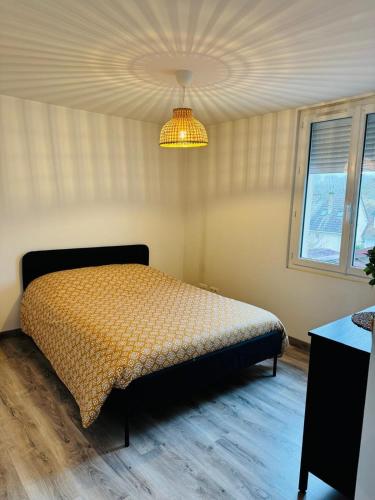 a bedroom with a bed and a chandelier at 4 - Parc Expo - Zénith - Sud 3 - Campus in Le Grand-Quevilly