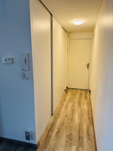 an empty hallway with a door and wooden floors at 4 - Parc Expo - Zénith - Sud 3 - Campus in Le Grand-Quevilly