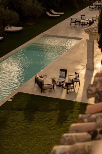 - un billard avec des tables et des chaises à côté de la piscine dans l'établissement La Maison - Grignan, à Grignan