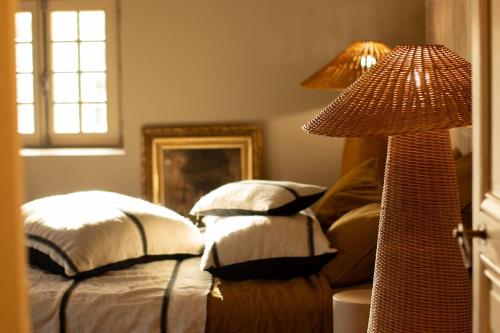 - une chambre avec un lit doté d'oreillers et d'une lampe dans l'établissement La Maison - Grignan, à Grignan