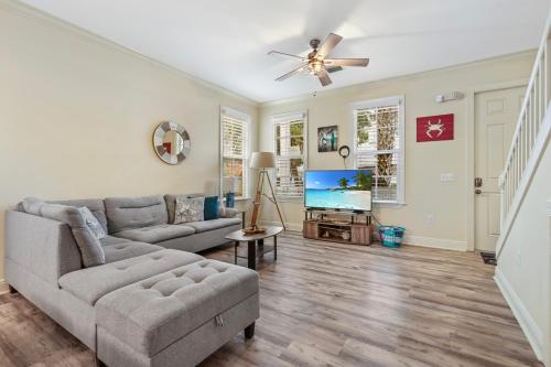 イスラモラダにあるAnglers Reef Islamorada 2BR 3BA Oceanview Home in Gated Community With Resort Style Pool, Private Beach and Marinaのソファと天井ファンのあるリビングルーム