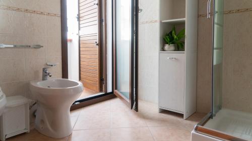 a bathroom with a toilet and a shower and a sink at La Casa di Asia in Tanaunella