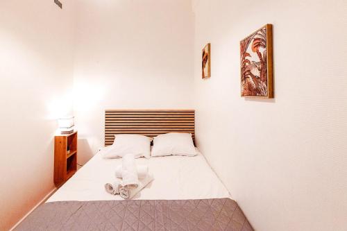 a small bedroom with a bed with white sheets at Studio lumineux idéalement situé in Bais