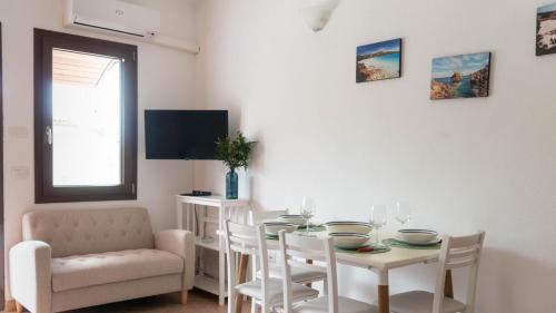 a dining room with a table and chairs and a television at La Casa di Asia in Tanaunella