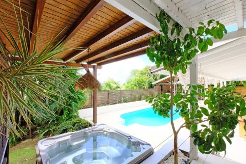 an outdoor hot tub in the middle of a yard with a pool at Oasis de tranquillité, Villa Lupio in Le Gosier
