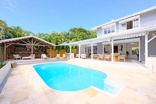 a swimming pool in the backyard of a house at Oasis de tranquillité, Villa Lupio in Le Gosier