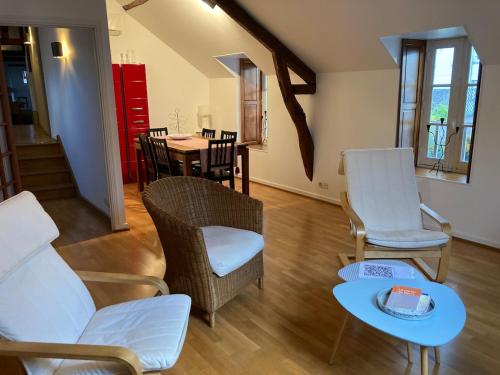 un salon avec un canapé, des chaises et une table dans l'établissement Appartement douillet, spacieux et convivial, à Vierzon