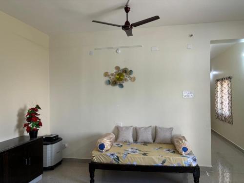 a living room with a couch and a ceiling fan at Annamaiah Premium & Grand - 2 & 3 BHK Apartments for Families - Homestay & Home Food Service in Tirupati
