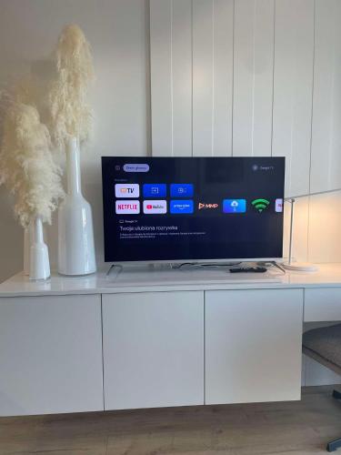 a tv sitting on top of a white cabinet at EASY RENT- Apartament z Widokiem in Lublin