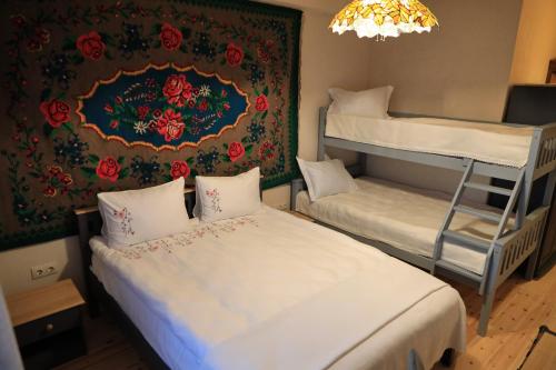 a room with two bunk beds and a wall with flowers at ECO Hotel Gagauz Sofrasi in Congaz