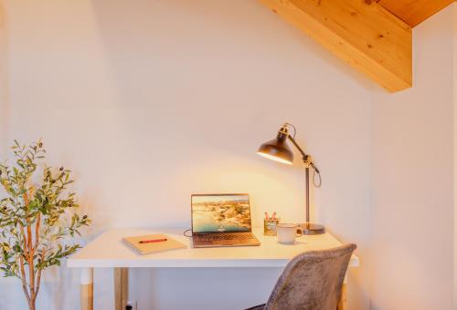 a desk with a laptop and a lamp on it at Tutzing Seeblick Apartment mit Balkon in Tutzing