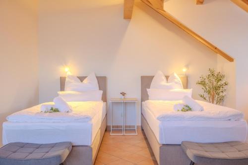 two beds with white pillows in a room at Tutzing Seeblick Apartment mit Balkon in Tutzing