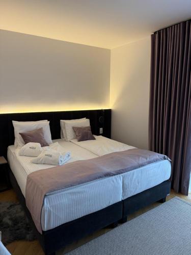 a bedroom with a large bed with white sheets and pillows at Marmotta Paltinis in Păltiniş