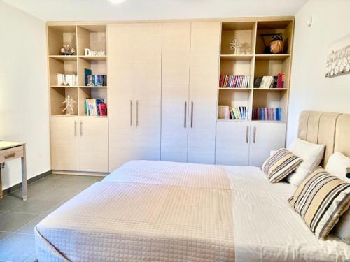 a bedroom with a large bed with white cabinets at Luxury modern villa with swimming pool, Athens Riviera in Lagonissi