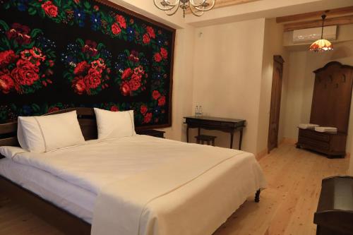 a bedroom with a bed with a large painting on the wall at ECO Hotel Gagauz Sofrasi in Congaz