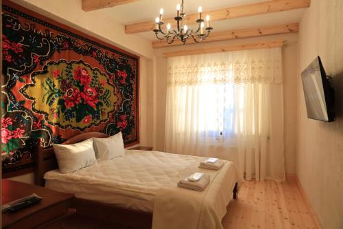a bedroom with a bed and a painting on the wall at ECO Hotel Gagauz Sofrasi in Congaz