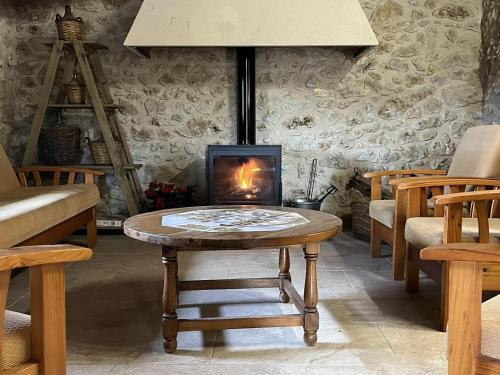 a living room with a table and a fireplace at CASA RURAL MASIA ARINESA Culla in Culla