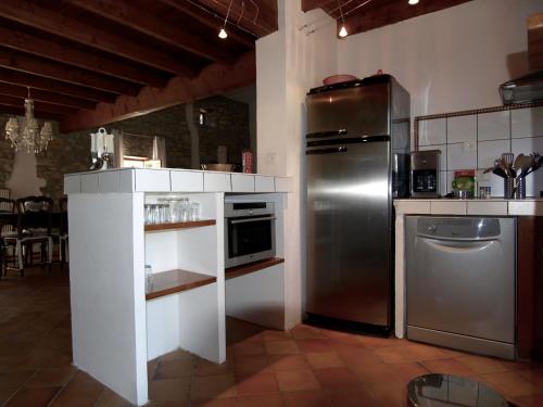 La cuisine est équipée d'un réfrigérateur en acier inoxydable et d'un lave-vaisselle. dans l'établissement Les MAGNANS, à Gailhan