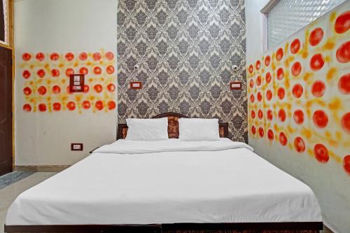 a bedroom with a white bed with oranges on the wall at Hotel O Shaani Guest House in Jawāharnagar