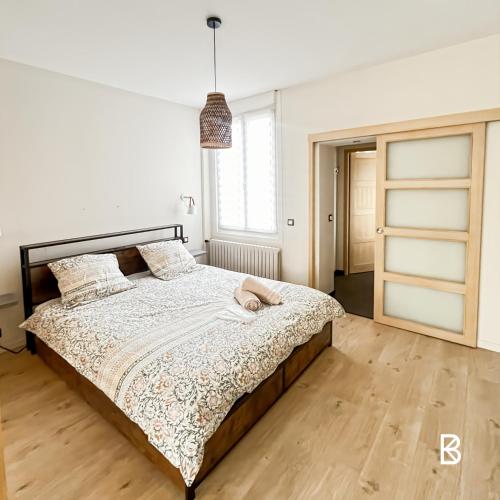 une chambre avec un grand lit avec un plancher en bois dans l'établissement L'Échapée Z'Aisne, à Saint-Quentin