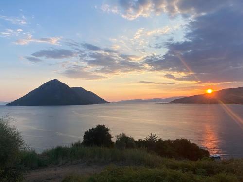 a sunset over a body of water with a mountain at Kalamos Bay View in Panagoúla