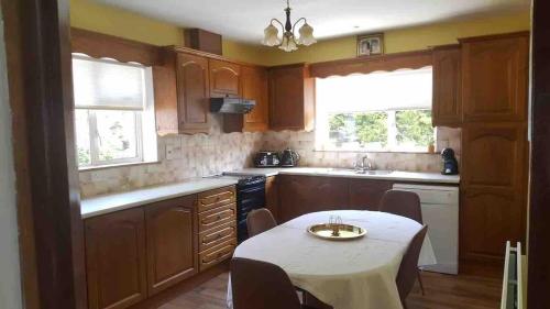 a kitchen with a table with chairs in it at Sunny South East Holiday Home in Clashmore