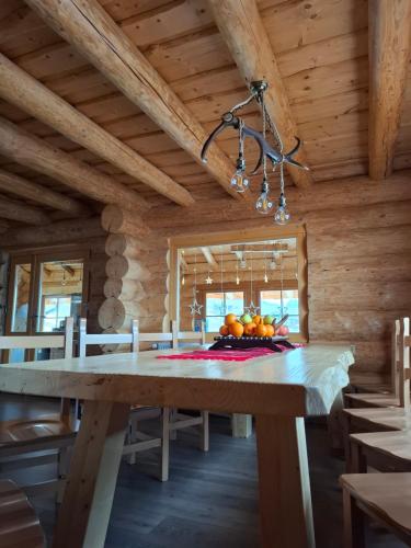 comedor con mesa en una casa de madera en Chalet Gabriela, en Şarul Dornei