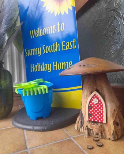 a book and a bird house on a counter at Sunny South East Holiday Home in Clashmore