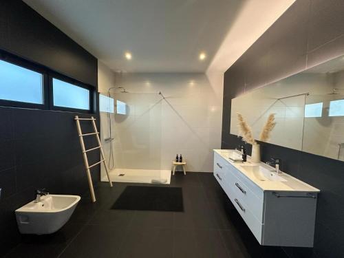 a bathroom with two sinks and a toilet and a shower at Cristy's Place in Cabouco