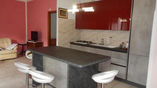 a kitchen with a counter with white stools in it at Casa della Nonna in Casale Monferrato